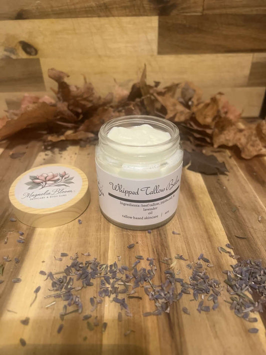 Whipped Tallow Balm with Lavender in a jar, surrounded by dried lavender and autumn leaves.